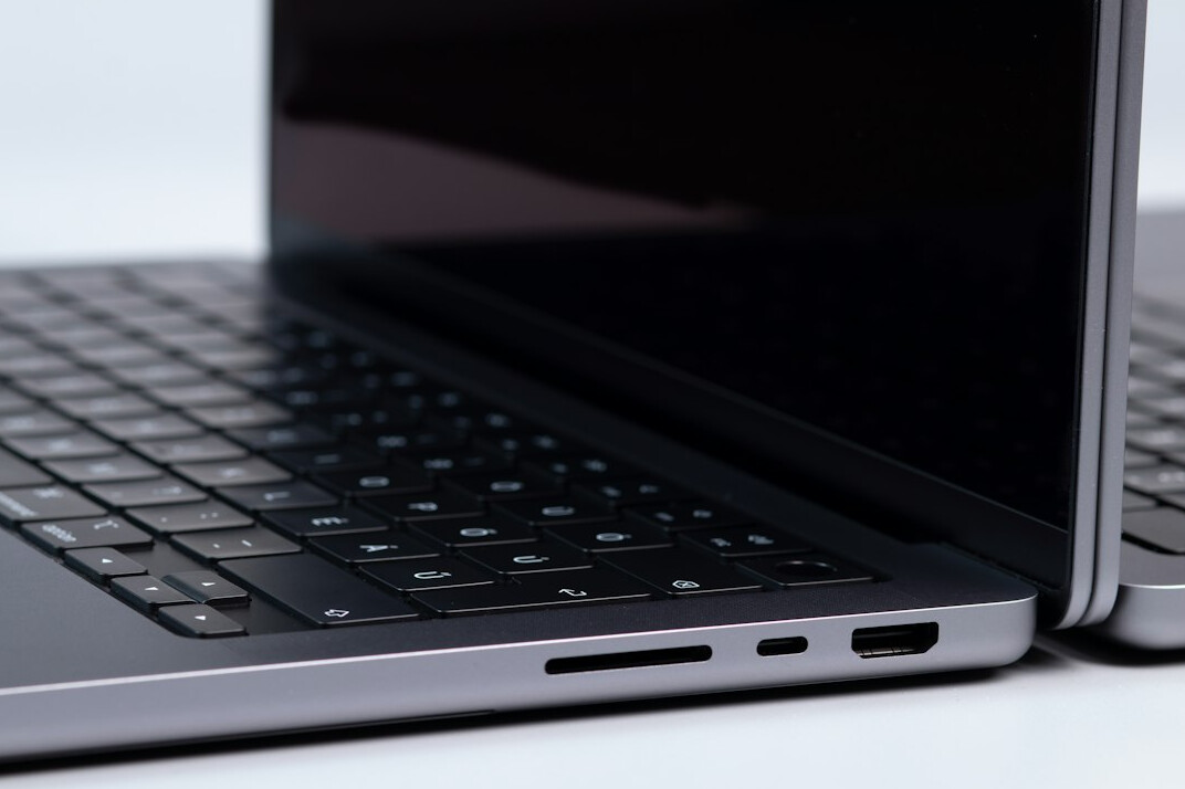 Close up of hands typing code on a laptop keyboard