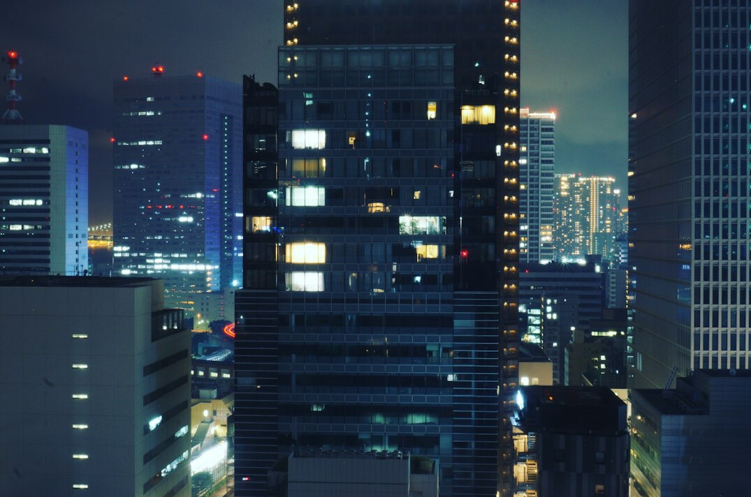 Software developers working late in a Tokyo office with city lights