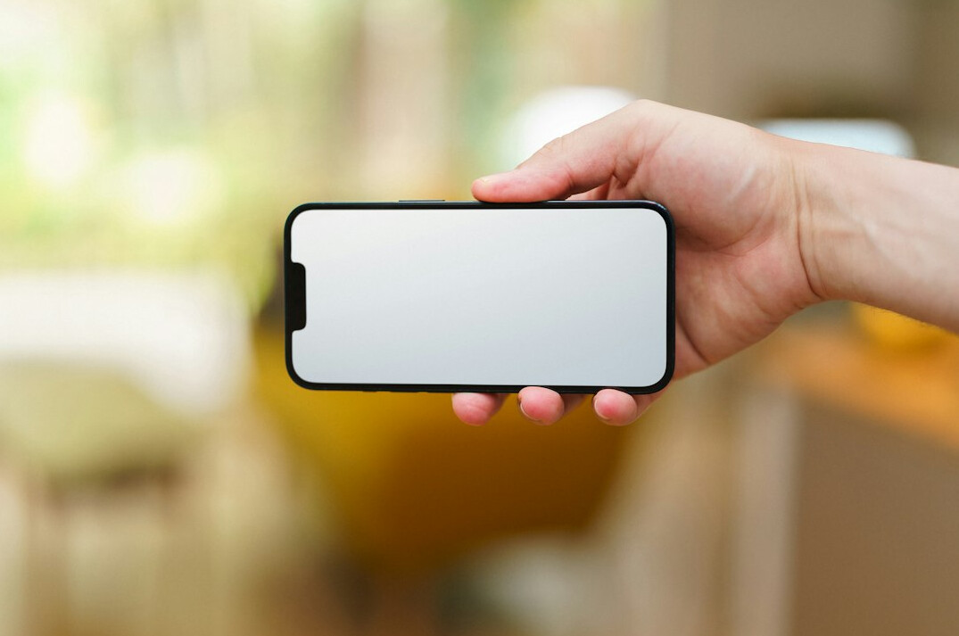 Hand holding a smartphone showing an insurance app interface